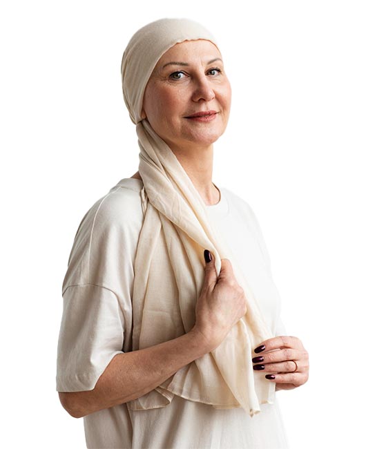 A person wearing a light-colored headscarf and a matching shirt stands against a plain white background. They have a slight smile and hold their scarf with one hand.